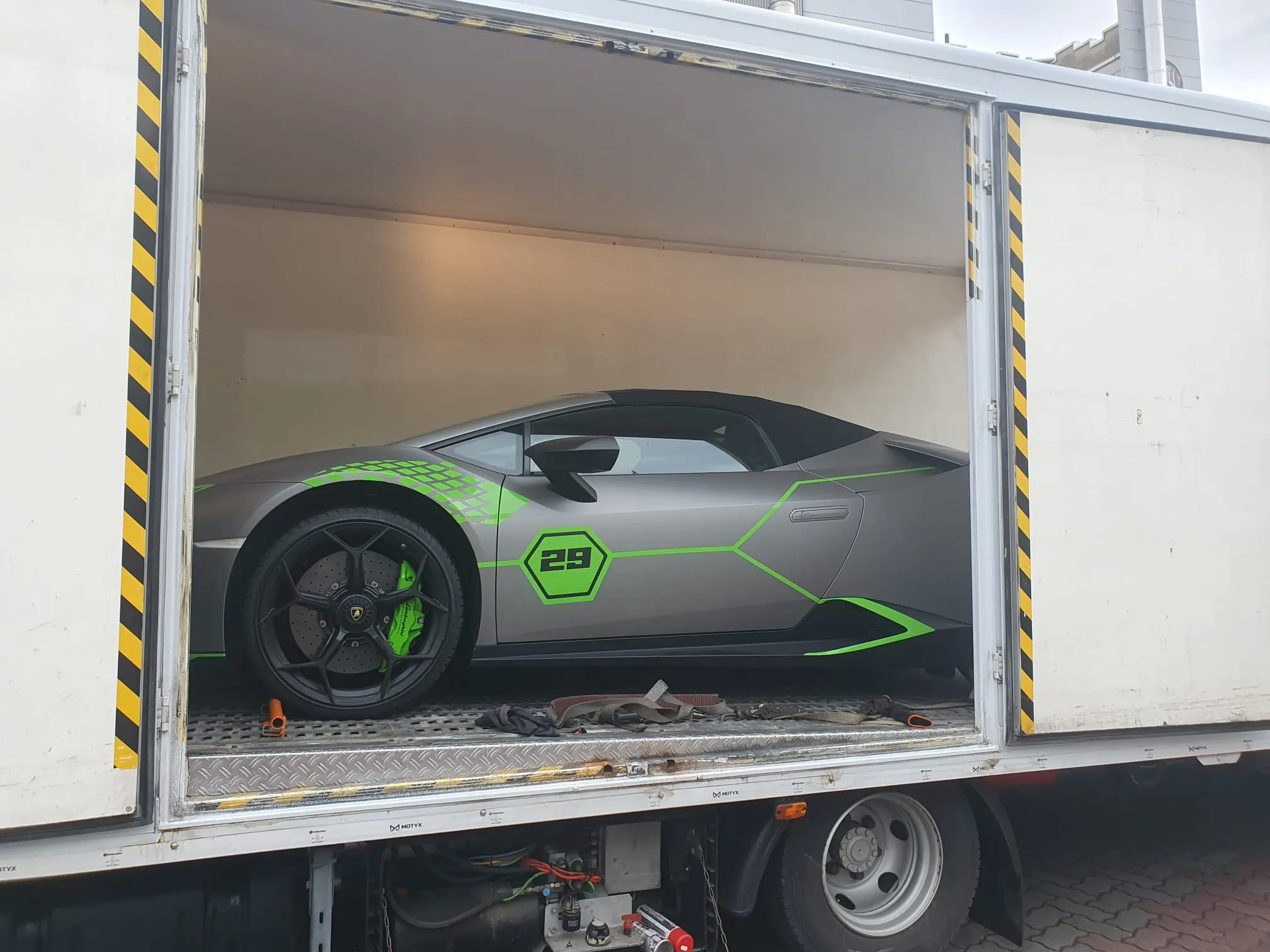 Huracán grigio opaco con grafiche verde acid nel furgone Lory